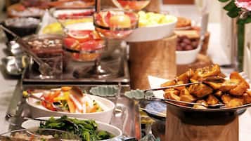 A buffet table with various dishes and food items.
