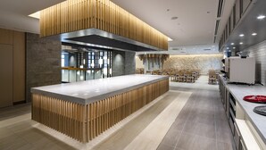 A modern kitchen with a central island, wooden accents, and a stone wall in the background.