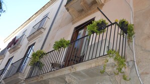 A building facade with balconies adorned with green plants.