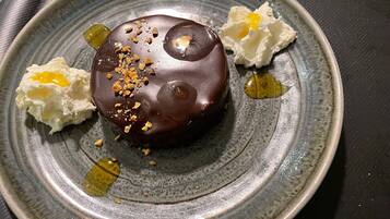 A dessert on a plate with chocolate and white cream.