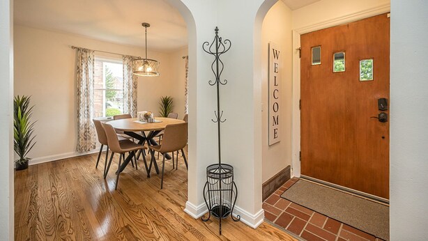A dining area with a table and chairs, a chandelier, and a coat rack. - Sweet Escape Near Historic Main St, 4BR, 2 Baths (Saint Charles)
