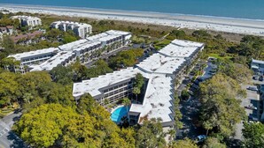 Ein Hotelkomplex am Küstenrand mit mehreren Gebäuden, Parkplätzen und Blick auf den Strand.