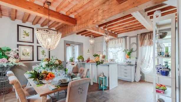 A spacious dining area with a wooden ceiling, a chandelier, and a kitchen with white cabinets and a window with curtains. - VILLA REGINA, 4 bedrooms and a luxury style among the vineyards by Lucca Town (Lucca)