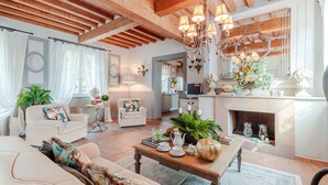 A spacious living room with a fireplace, wooden beams, and a chandelier. - VILLA REGINA, 4 bedrooms and a luxury style among the vineyards by Lucca Town (Lucca)
