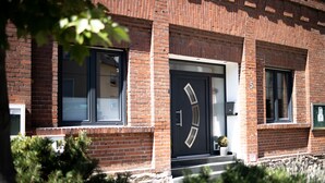 A brick building with a black door, windows, and a small potted plant on the steps. - Vacation with a view of the unique Marksburg Castle (Braubach)