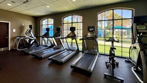 A gym with treadmills, stationary bikes, and a rowing machine.