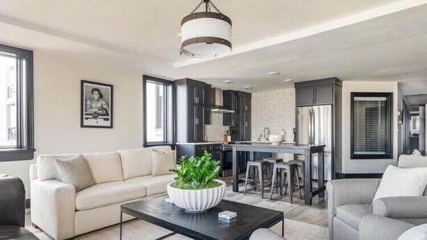 A modern living room with a sofa, coffee table, and a kitchen area in the background. - Cassius Quarters@The713! Downtown, large, upscale suite w/private balcony (Louisville)
