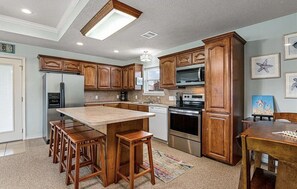 Enjoy cooking in this well-equipped kitchen with a central island, dining table, and modern appliances.