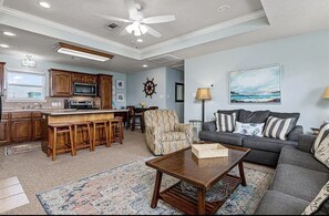 Relax in this stylish living space with a kitchen area, sofa, and coffee table.
