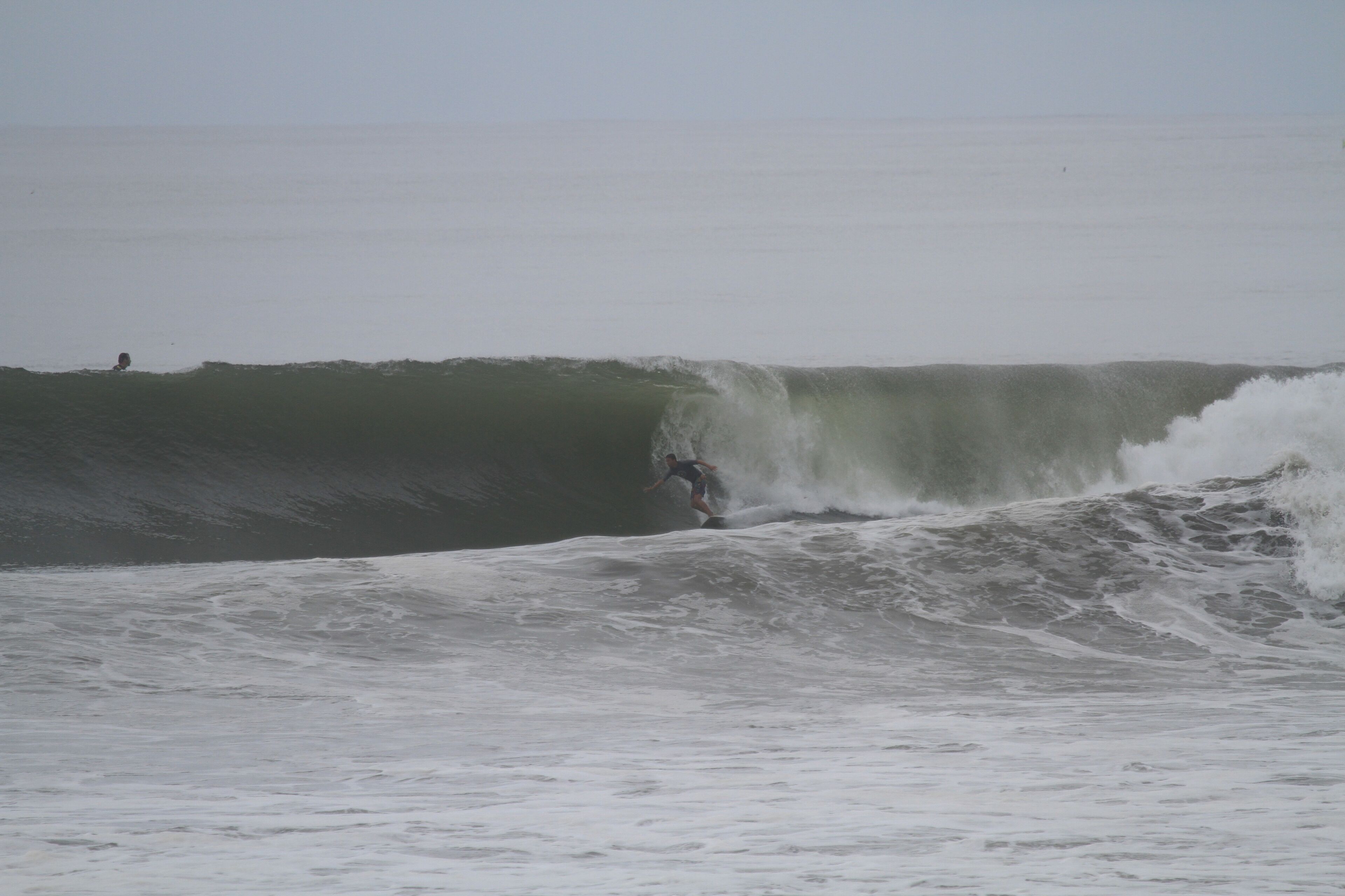 A surfer riding a large wave in the ocean.