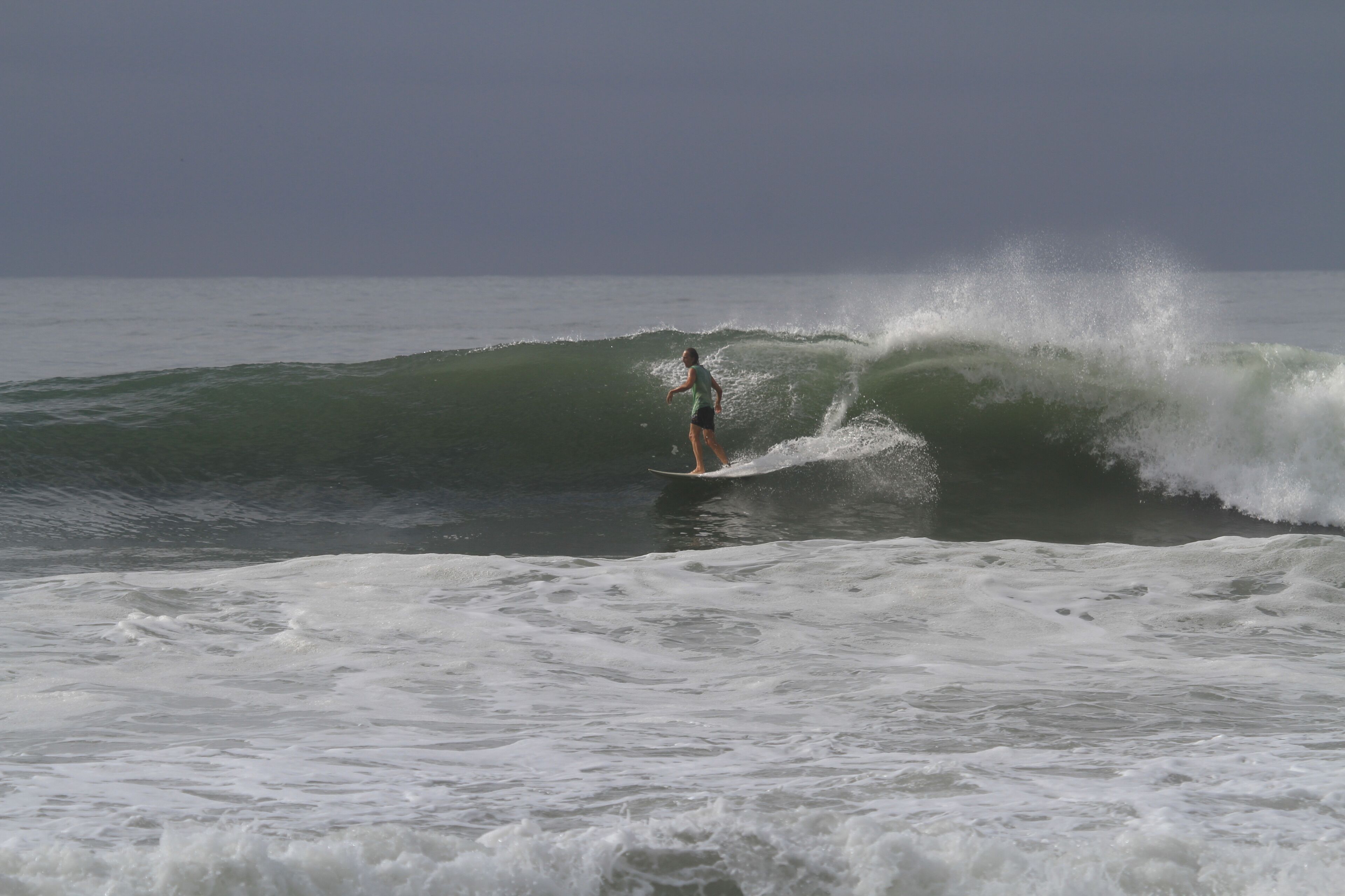 A person surfing on a wave in the ocean.