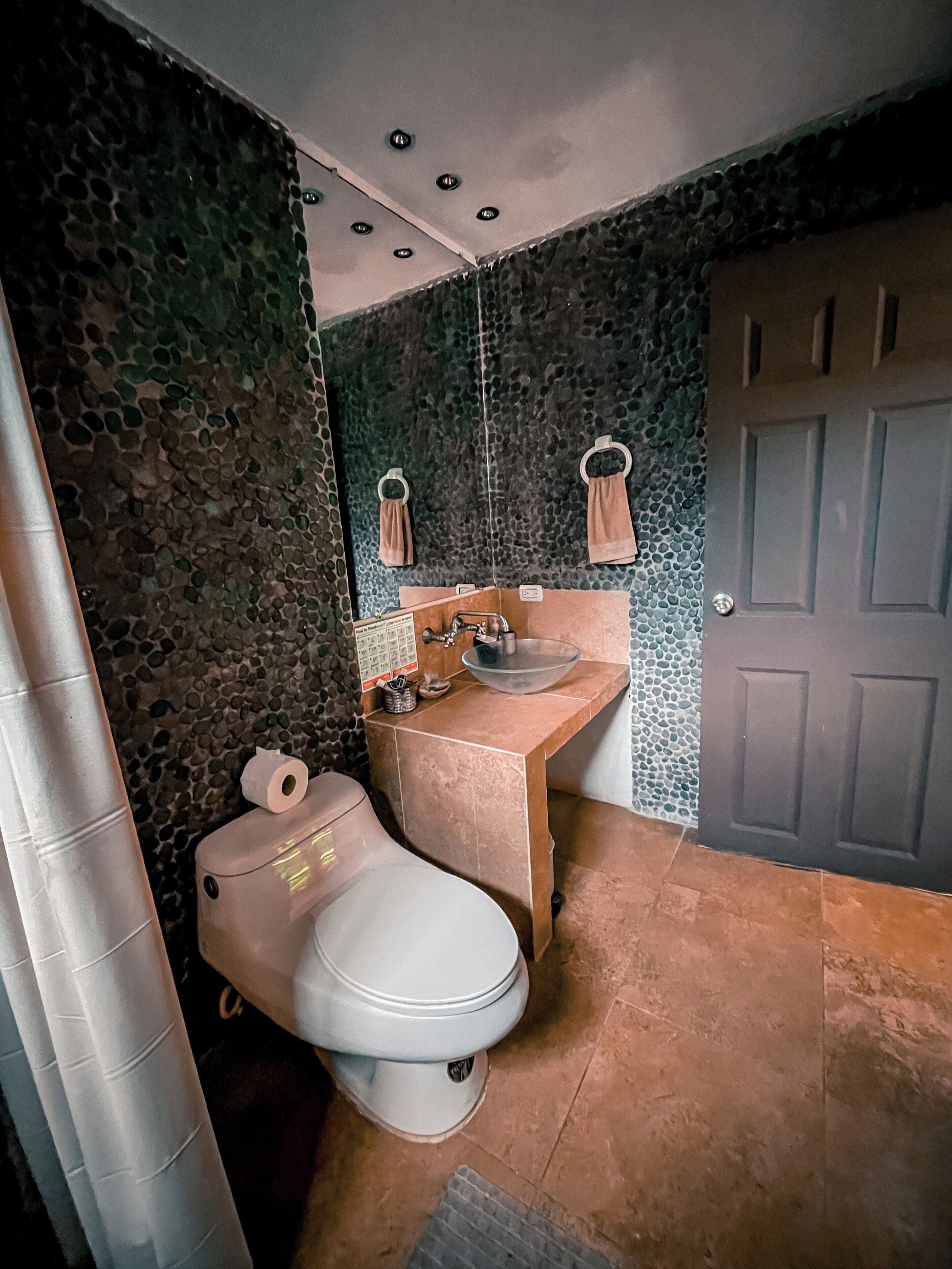 A bathroom with a toilet, sink, and mirror.