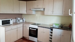 A compact kitchen with a microwave, toaster, kettle, and stove. - Quiet country house (Triguères)