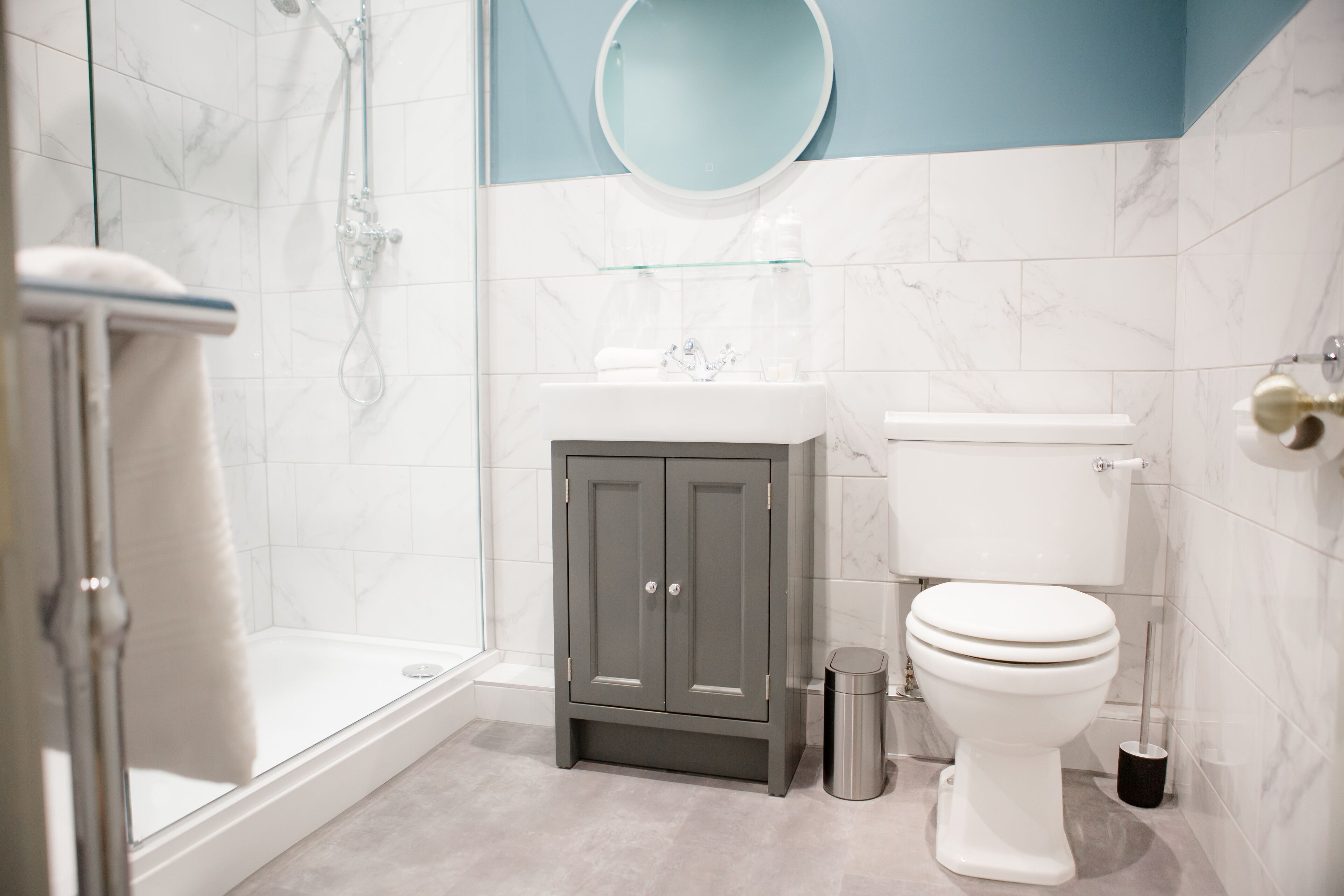 Un baño con ducha, inodoro y tocador.