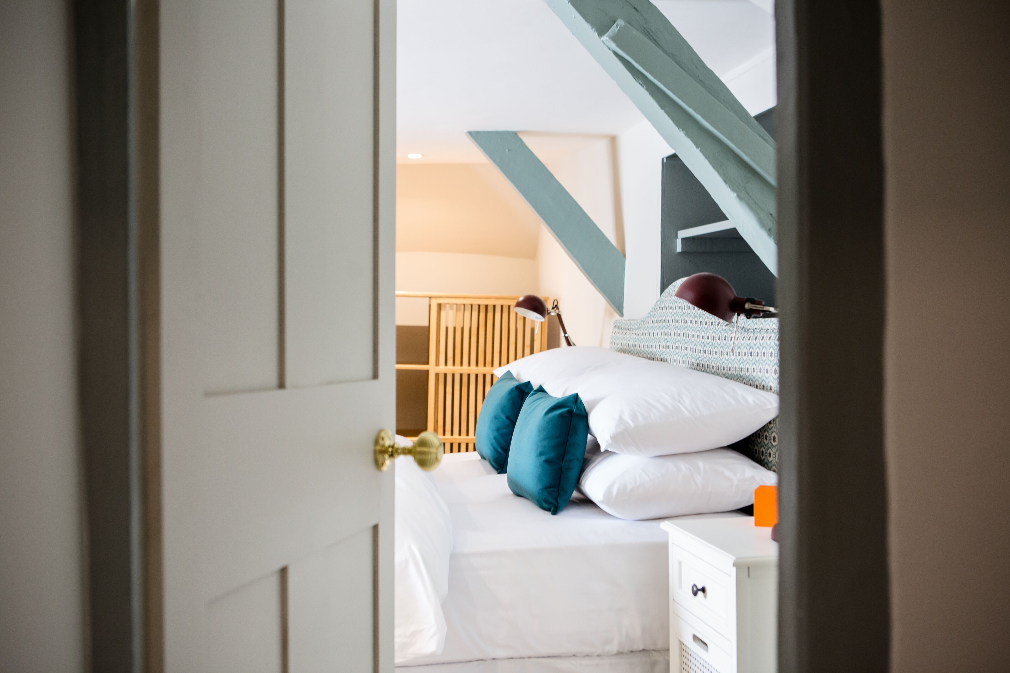 A bedroom with a bed, pillows, a nightstand, and a wardrobe.