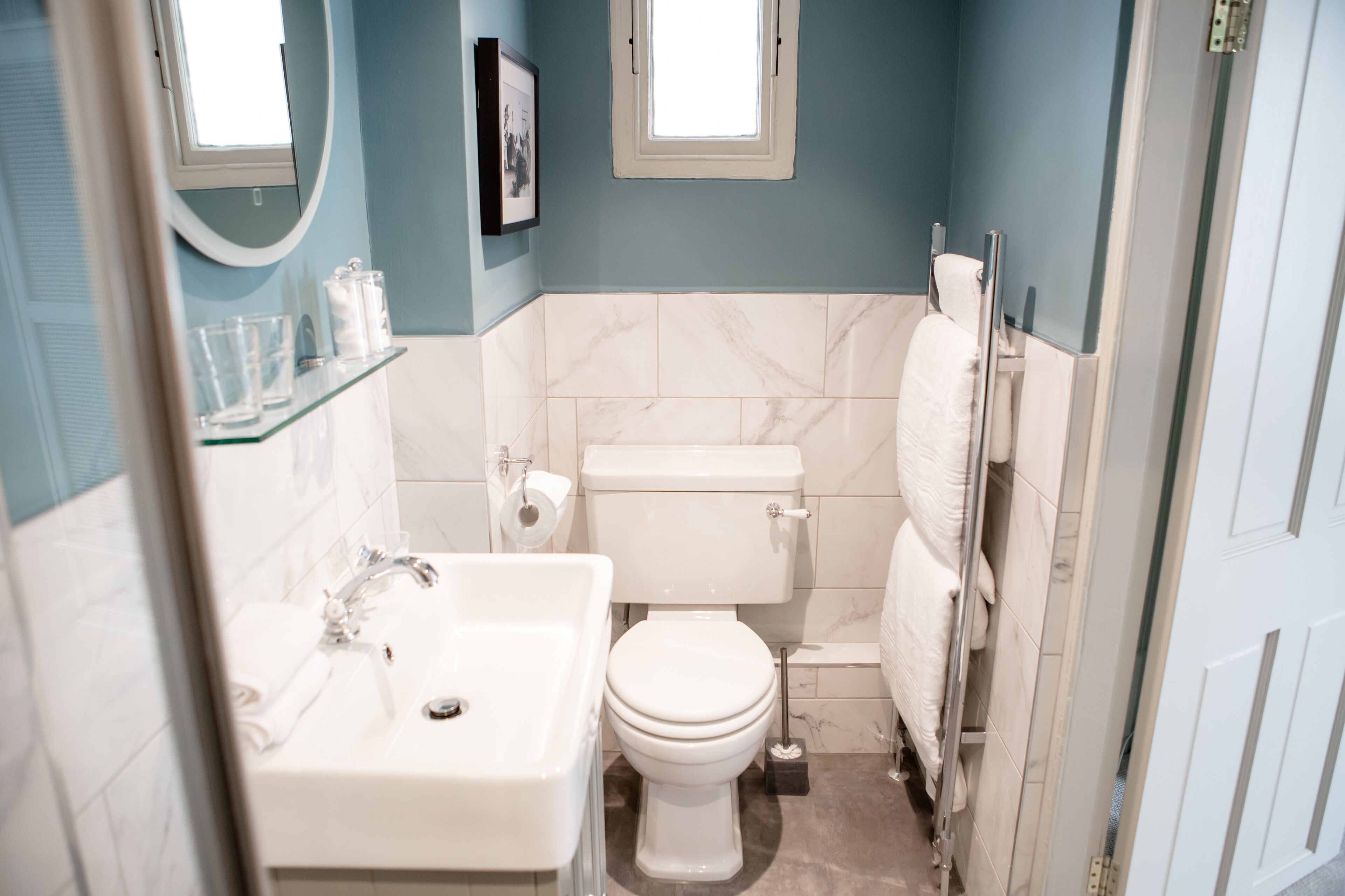 A bathroom with a white sink, toilet, and marble tiles.
