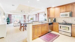 Una cocina moderna con armarios de madera, electrodomésticos de acero inoxidable y una isla central.