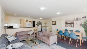 A modern apartment with a living room, kitchen, and dining area. - Silvertrees - 2/1 McLure Cir (Jindabyne)