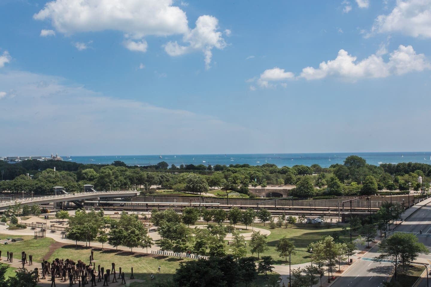 A park with a bridge, pathways, and a view of the sea.