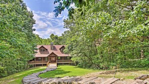 A lodge with a wooden exterior, a covered porch, and a stone chimney. - Spacious & Secluded Cabin: 25 Mi to Bentonville! (Sulphur Springs)