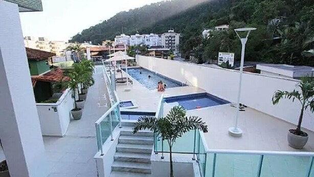 Una piscina en la azotea con vistas despejadas de los edificios circundantes y un paisaje montañoso.