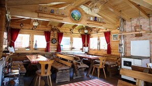 A rustic wooden interior with a long communal table, benches, and a white refrigerator. - Ellerbeck Gesundheits- und Wellnesshof (Langdorf)
