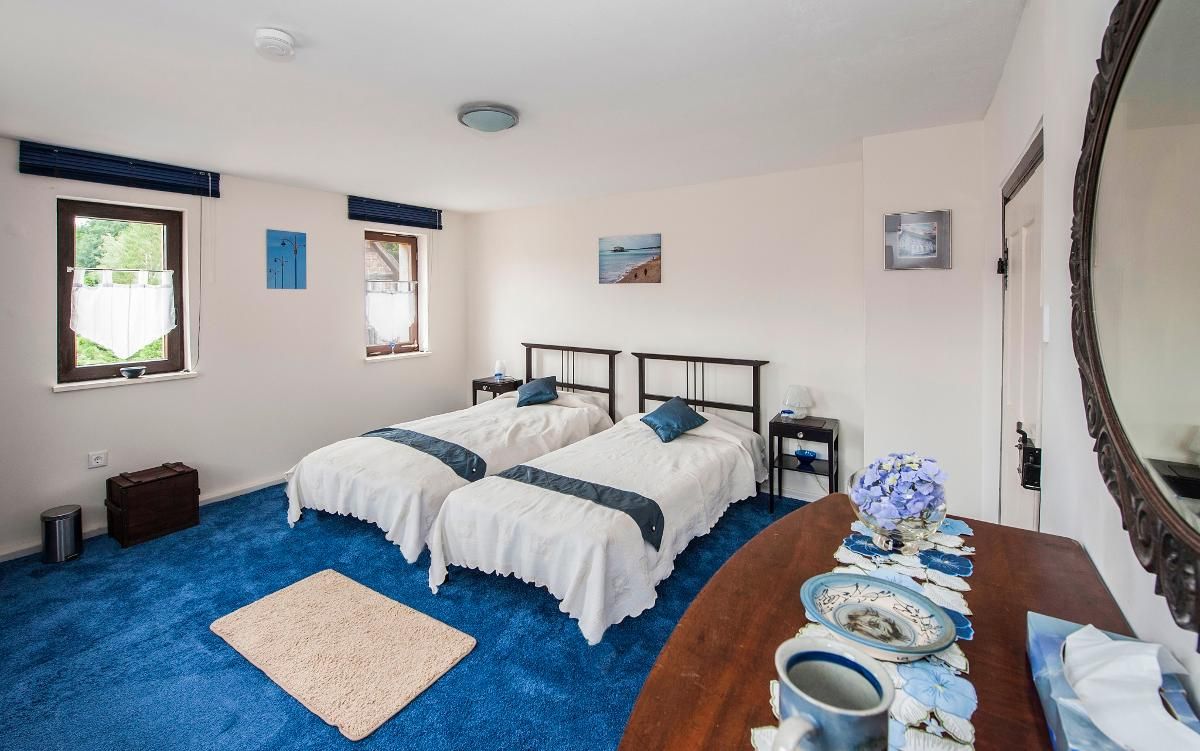 Un dormitorio con dos camas, un aparador de madera, un espejo y una ventana con cortina.