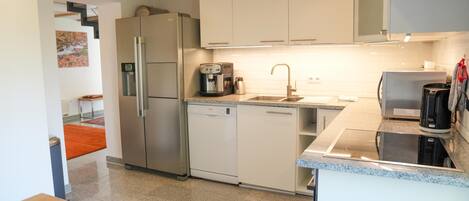 A modern kitchen with stainless steel appliances, a dishwasher, and a coffee maker.