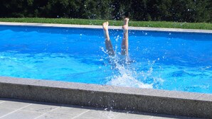 A swimming pool with clear blue water and a tiled edge. - Ferienwohnungen Martina (Windorf)