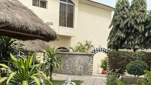 A house with a thatched roof, a stone wall, and a gate. - Haitel Guest Inn (Kano)