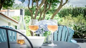 Uma mesa com uma garrafa de vinho, duas taças de vinho e uma tigela de flores.