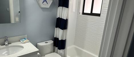 A bathroom with a toilet, sink, and bathtub.