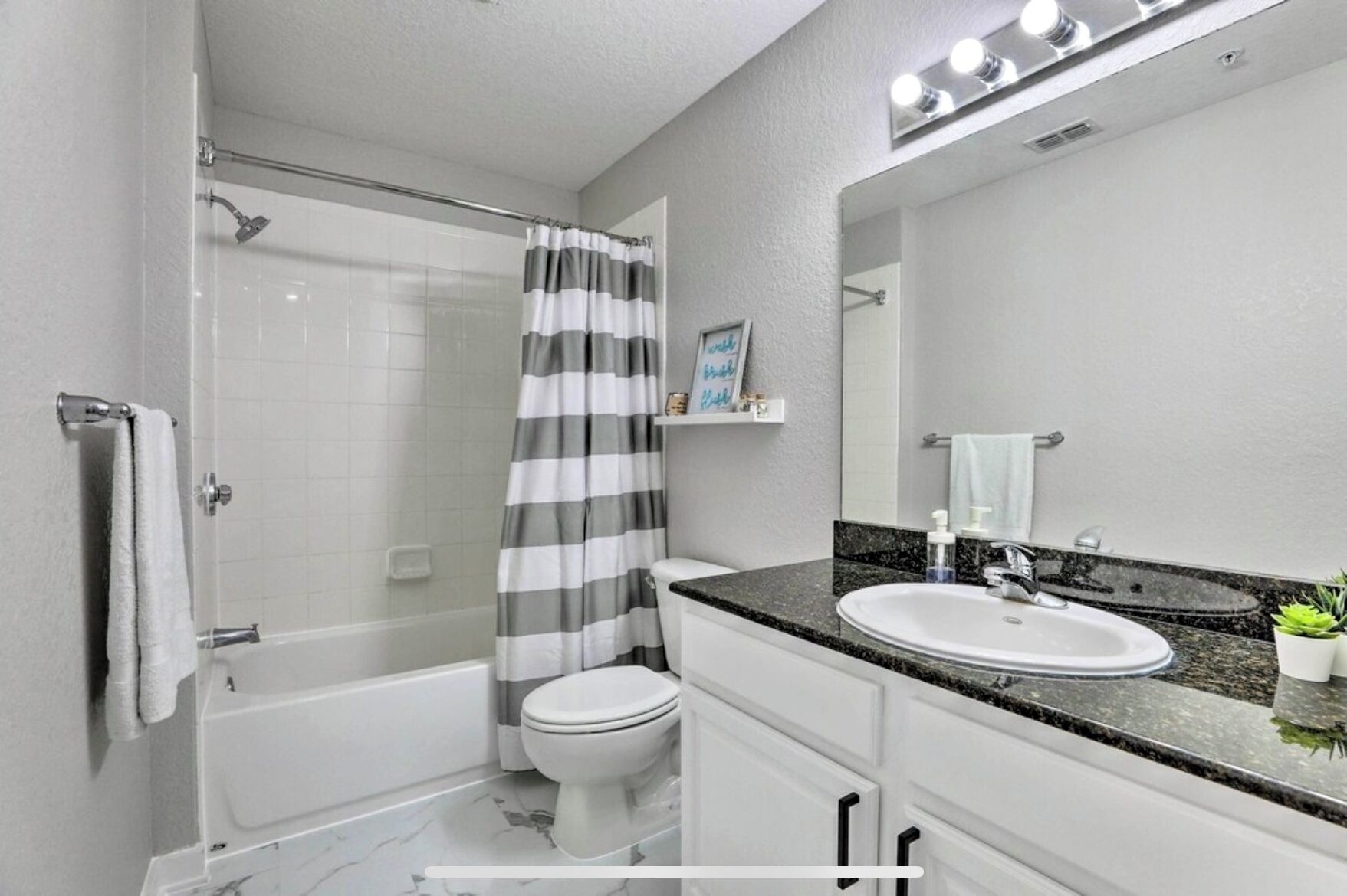 A modern bathroom with a shower, toilet, and sink.