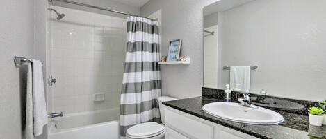 A modern bathroom with a shower, toilet, and sink.