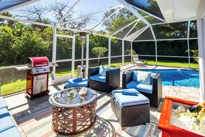 Relax by the pool with comfortable seating and a barbecue grill.