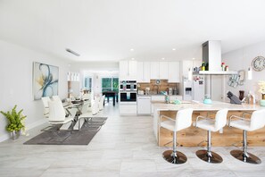 Enjoy meals in the well-lit kitchen with a central island, bar stools, and stainless steel appliances.