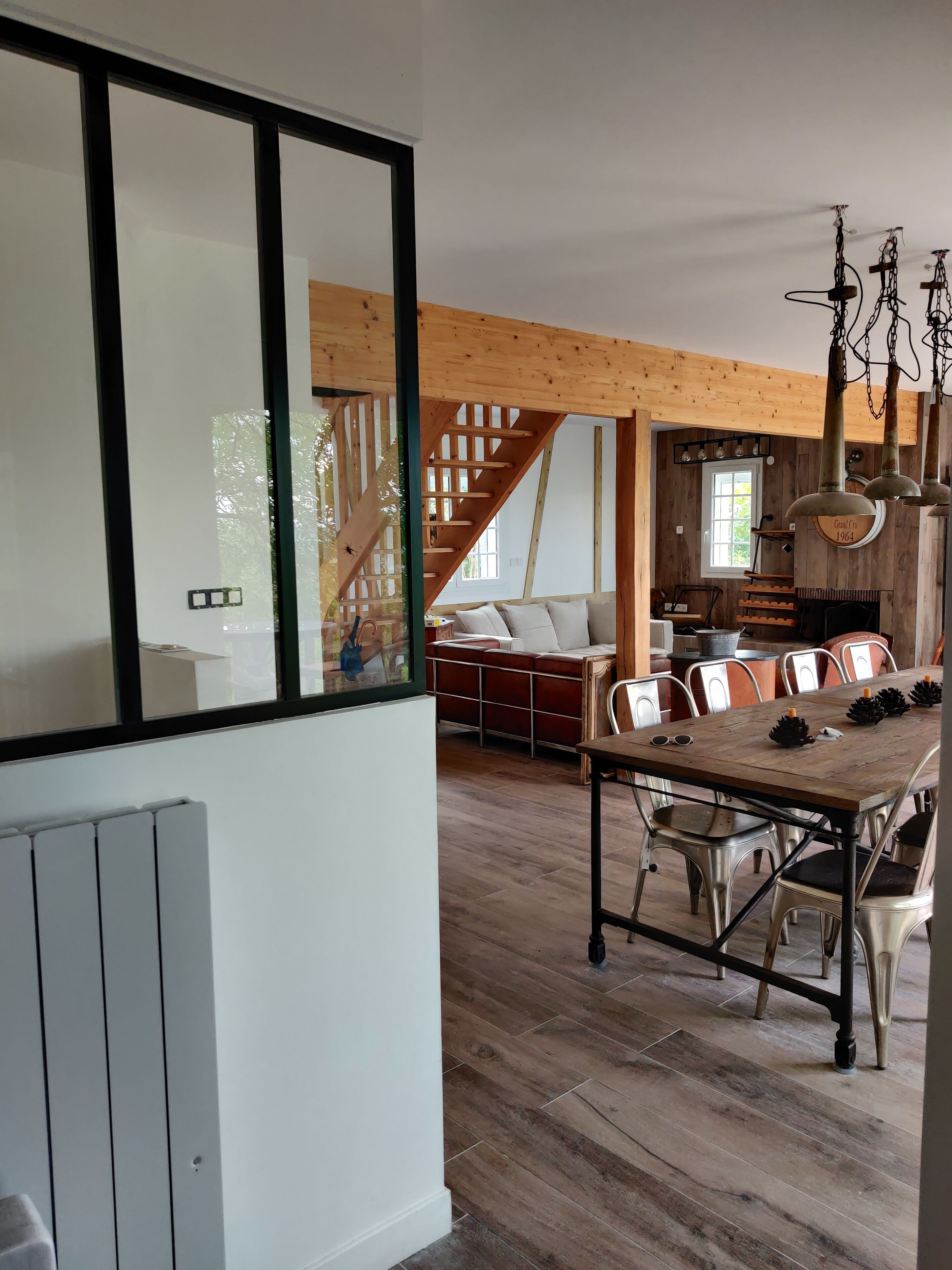 Vue de la cuisine sur salon et escalier a gauche conduisant au RDJ