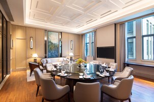 A conference room with a round table, white chairs, and a large window.