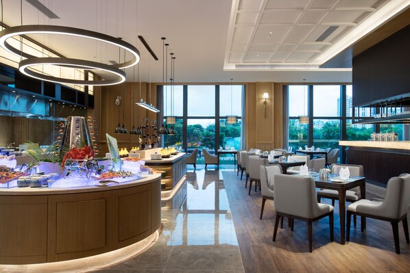 A modern restaurant with a central bar area, dining tables, and chairs.