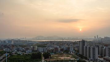 Une vue urbaine avec une rivière, un pont et un coucher de soleil.
