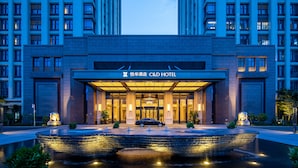 A hotel entrance with a fountain, a car in front, and a sign reading "C&D Hotel". - C&D Hotel,Xiamen Xiang'an (Xiamen)