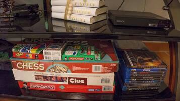 Uma estante com jogos de tabuleiro, DVDs e livros.