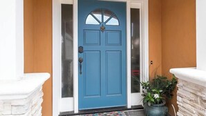 A blue door with a white frame, a small window, and a decorative element above the door. - Oceanview (Aptos)