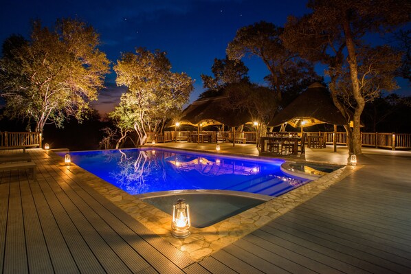 Una piscina al aire libre, sombrillas, tumbonas
