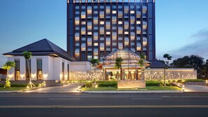 A modern hotel with a prominent building and a well-lit entrance.