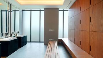 Relax in a serene bathroom with a central bench, lockers, and sinks with mirrors.