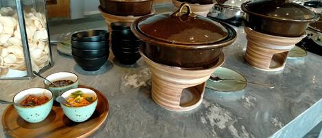 A buffet setup with various dishes and containers.