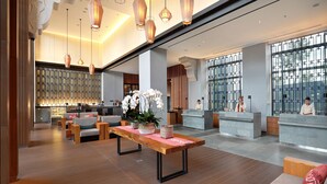 A spacious lobby with a reception desk, seating area, and a large window providing a view of the outside.