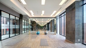 Un couloir moderne avec des murs en verre, un plancher en bois et une allée centrale.