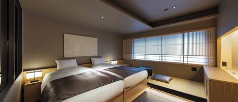 Un dormitorio moderno con una cama grande, mesitas de noche, un banco empotrado y una ventana con persianas.